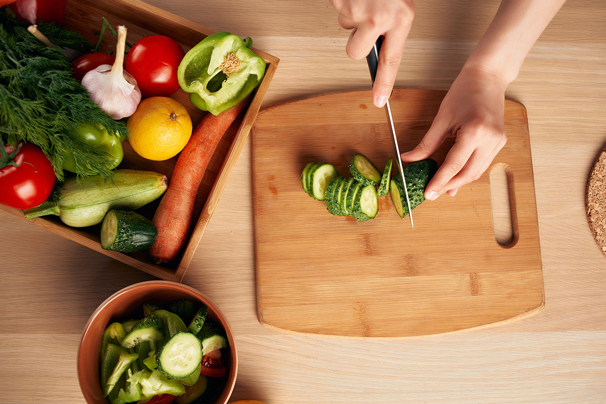 Chopping fresh vegetables while preparing a meal at home